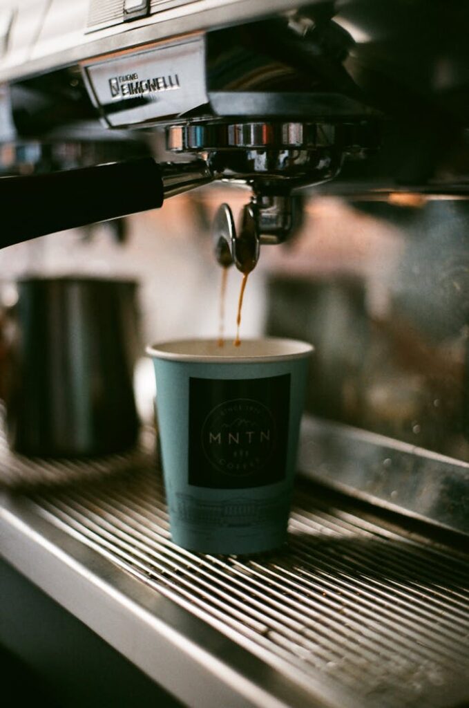 Close-up of an espresso machine brewing fresh coffee into a cup.